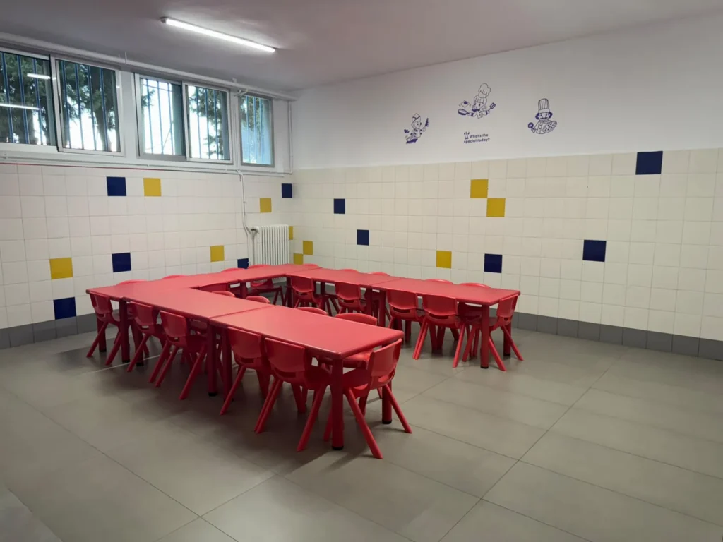 Mesas bajas y sillas rojas para el alumnado de Infantil en el comedor escolar de Juan XXIII Zaidín