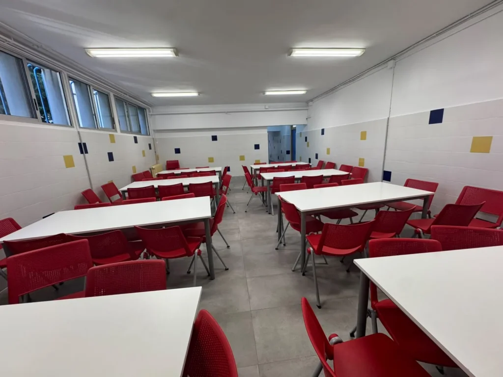 Filas de mesas y sillas en el comedor escolar de Juan XXIII Zaidín