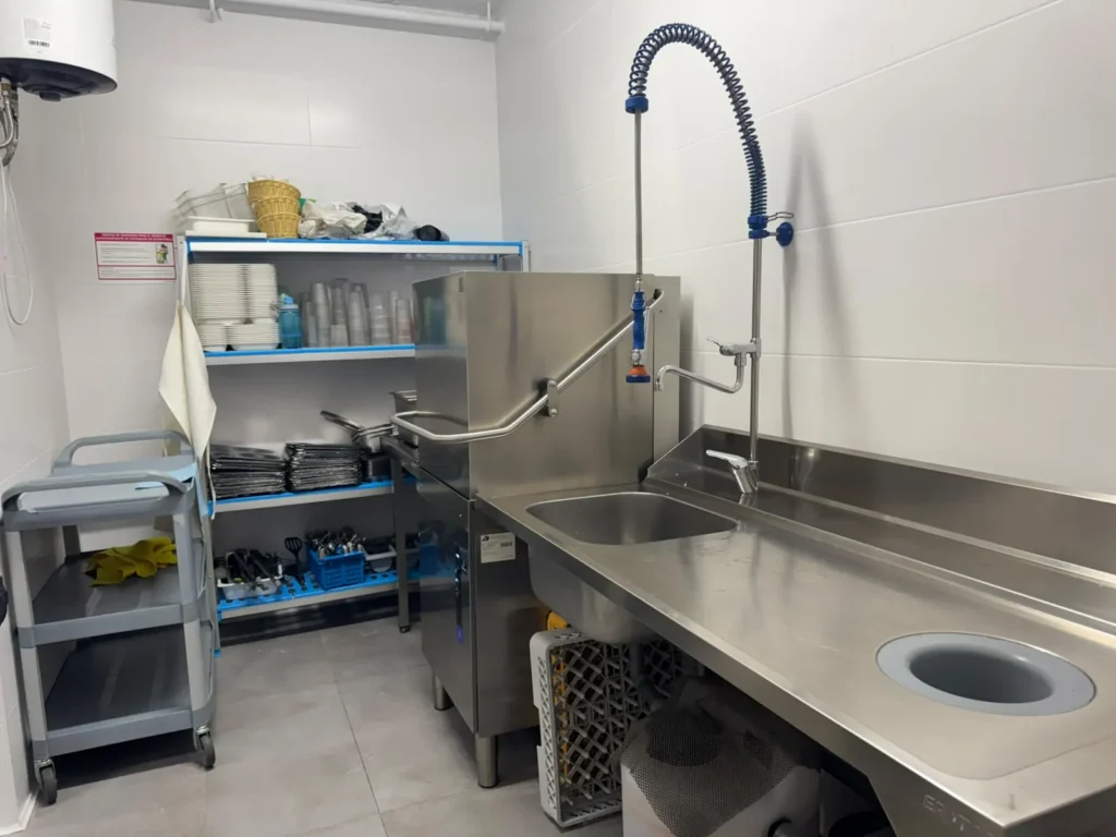 Fregadero de acero inoxidable con grifo de ducha en la zona de fregado de la cocina